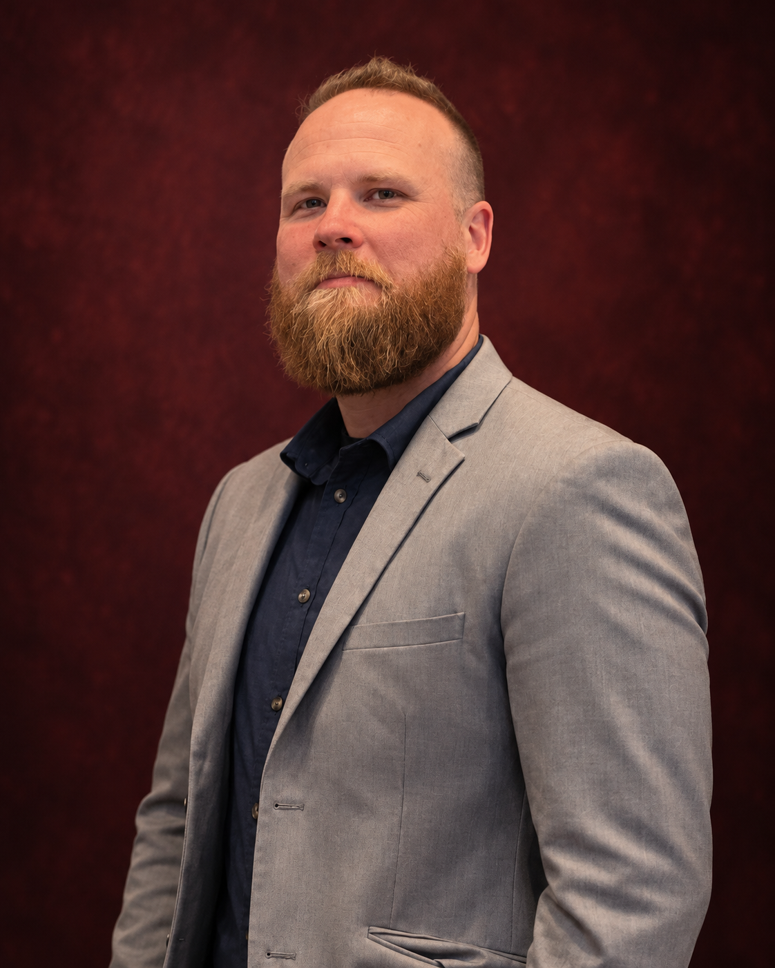 Martin Tippet in a gray blazer; AI-edited portrait based on his photograph